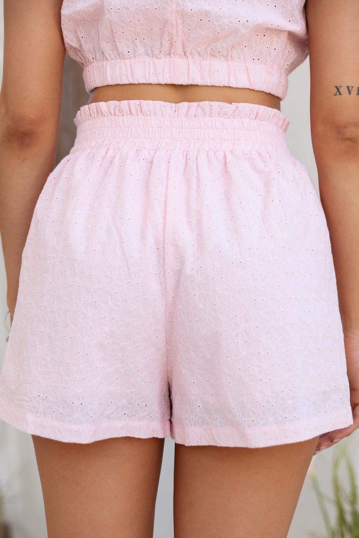 Back view of Ebba Shorts in soft pink, featuring a mid-high waist, elastic waistband, and lined pockets.