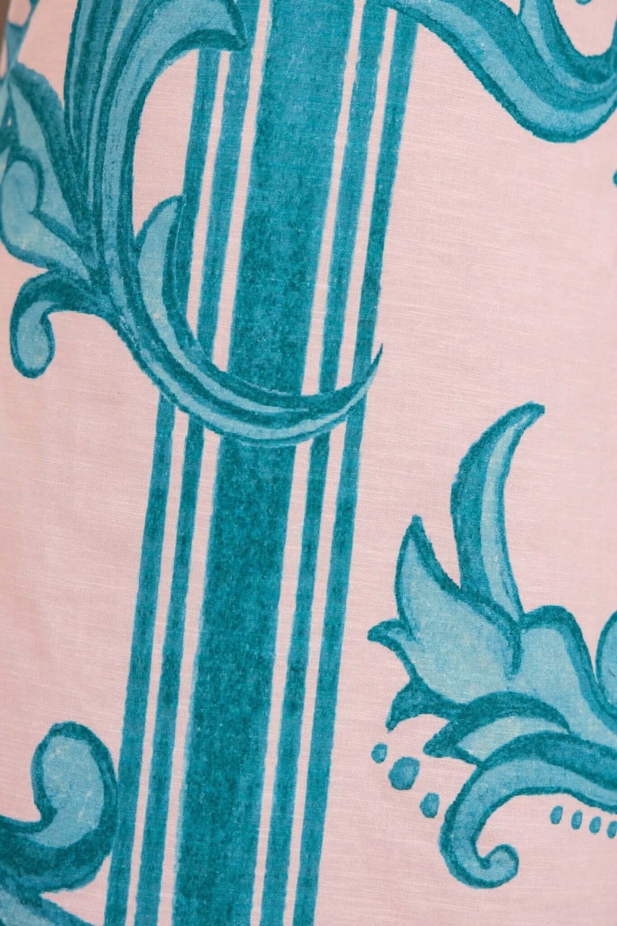 Close-up of Argenta Dress fabric featuring turquoise floral patterns and stripes on a soft background.