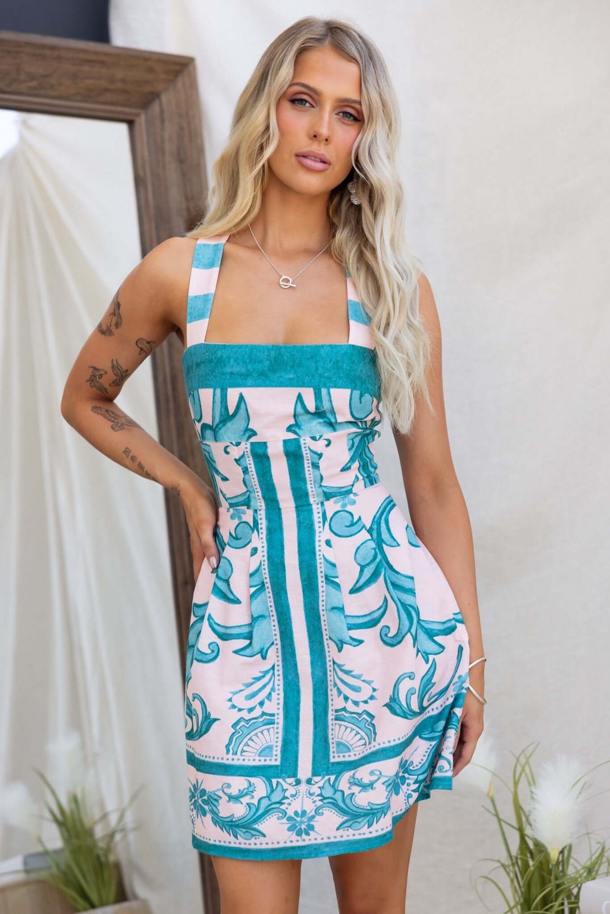 Argenta Dress featuring adjustable straps, pockets, and a linen look in turquoise and pink patterns.