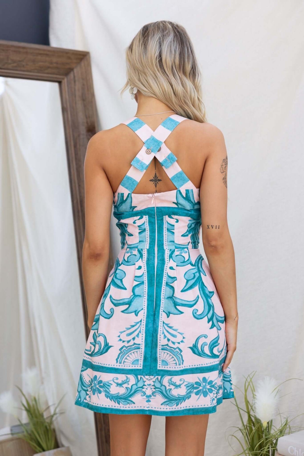 Back view of the Argenta Dress featuring adjustable straps and a colorful floral print.