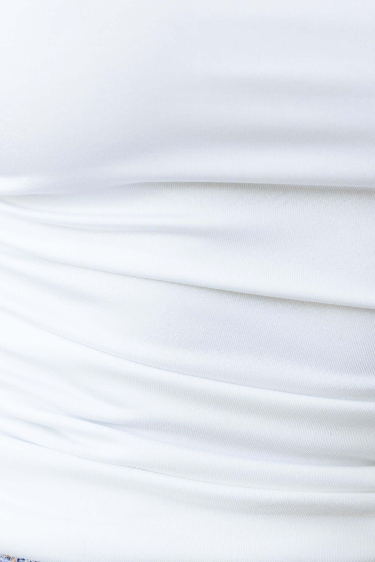 Close-up of white Dottie Top showing side ruching detail and smooth fabric texture.