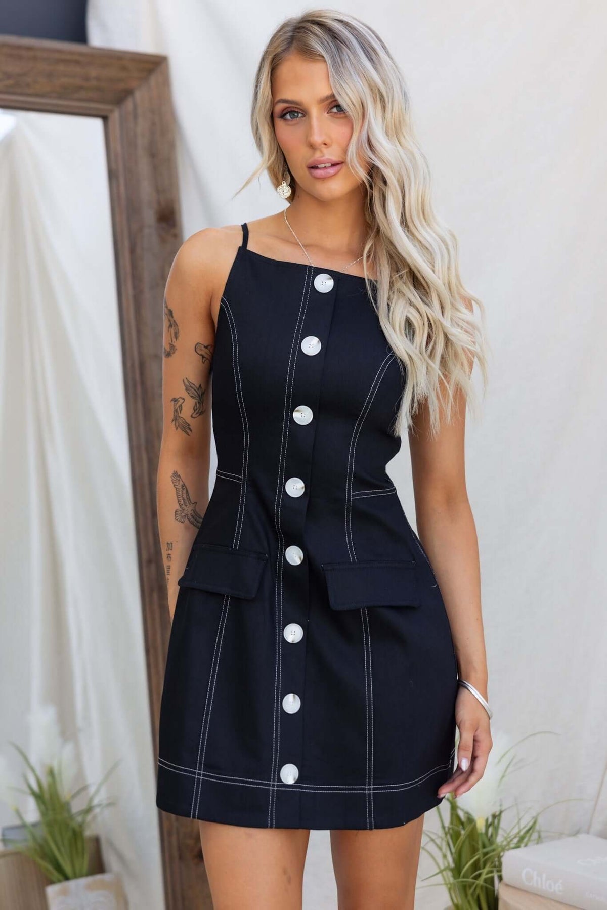 Black Olean Dress featuring faux buttons, invisible zip, faux pockets, and a stylish fitted design.