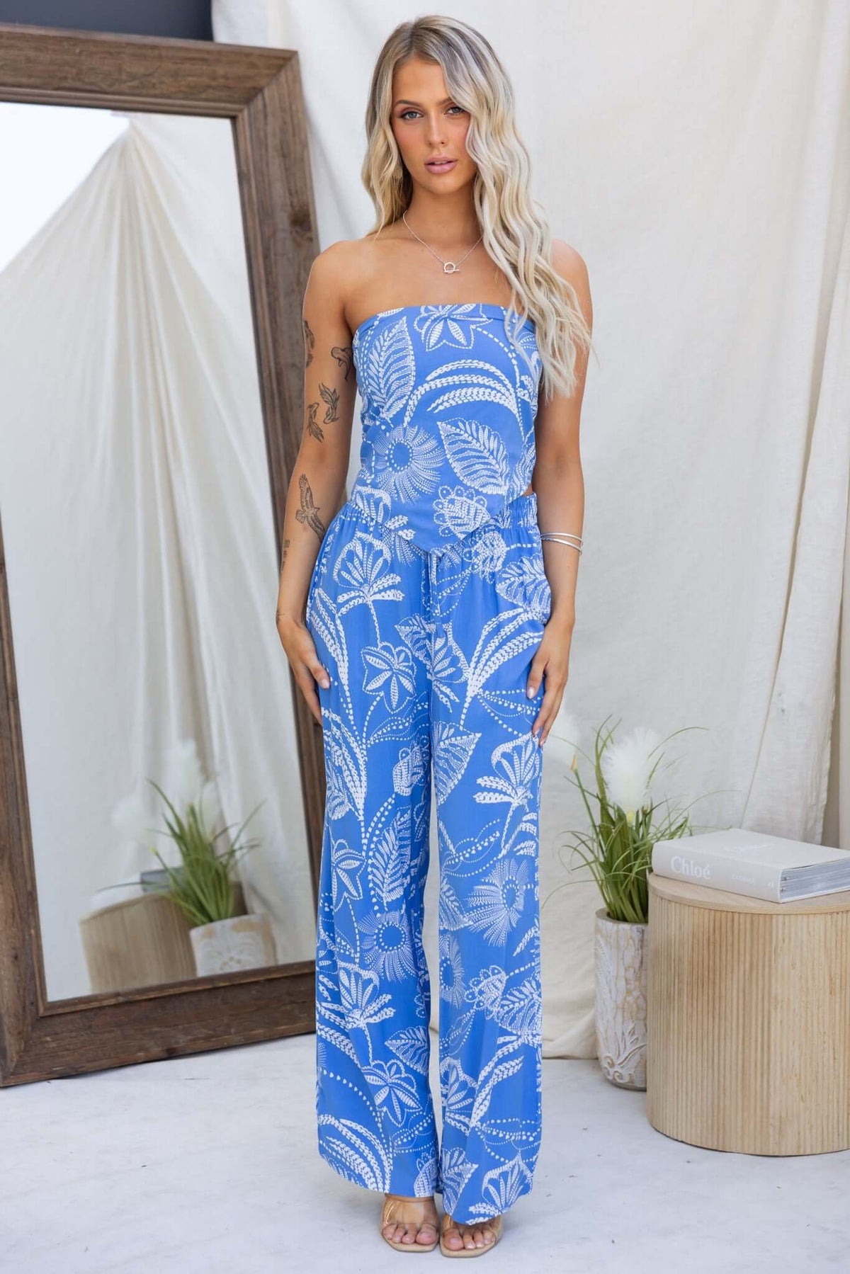 Model wearing a stylish blue strapless lasan set with floral patterns, featuring wide-leg pants and a drawstring waistband.