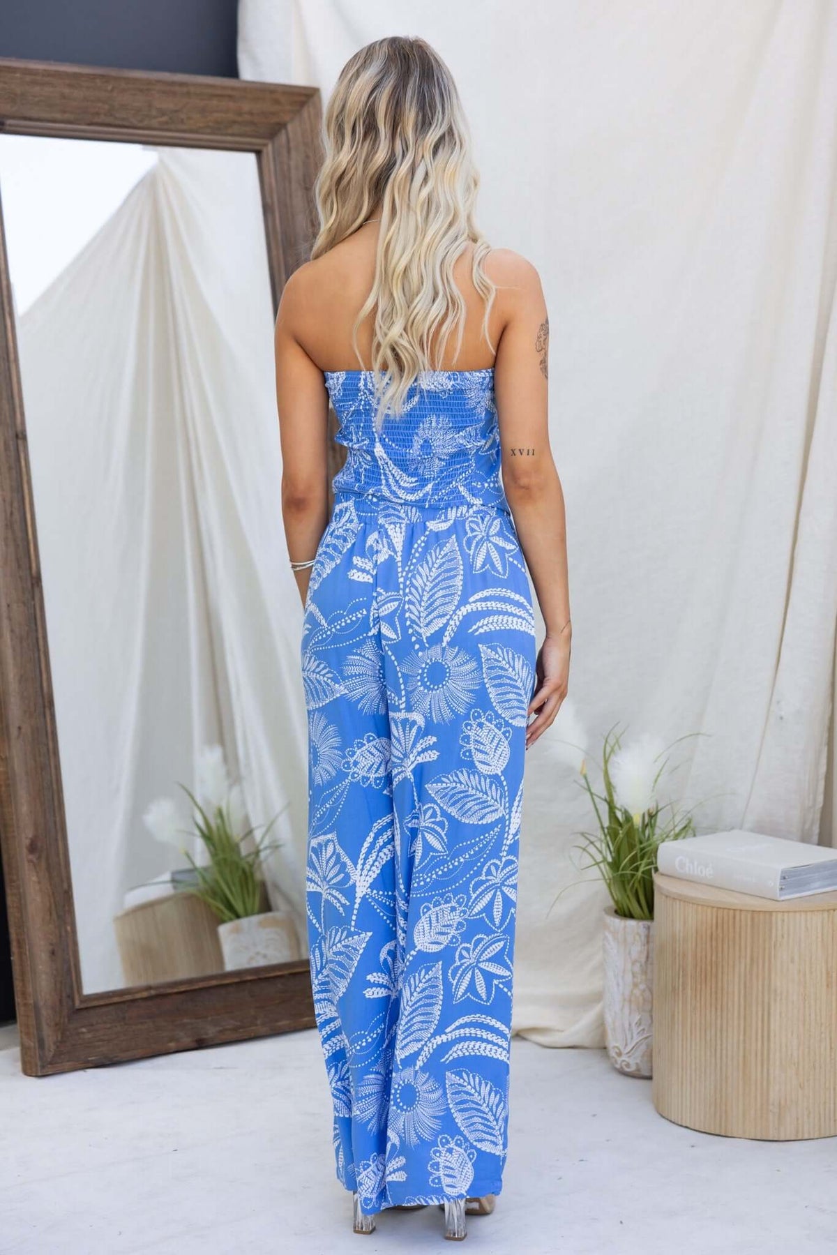 Model wearing a blue strapless Lasan set with floral print, showcasing the back view and mid-high waist fit.