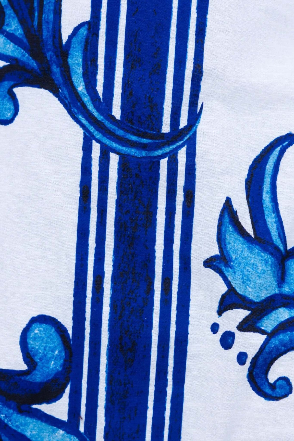 Close-up of blue floral pattern on fabric with vertical stripes, highlighting texture and intricate design.