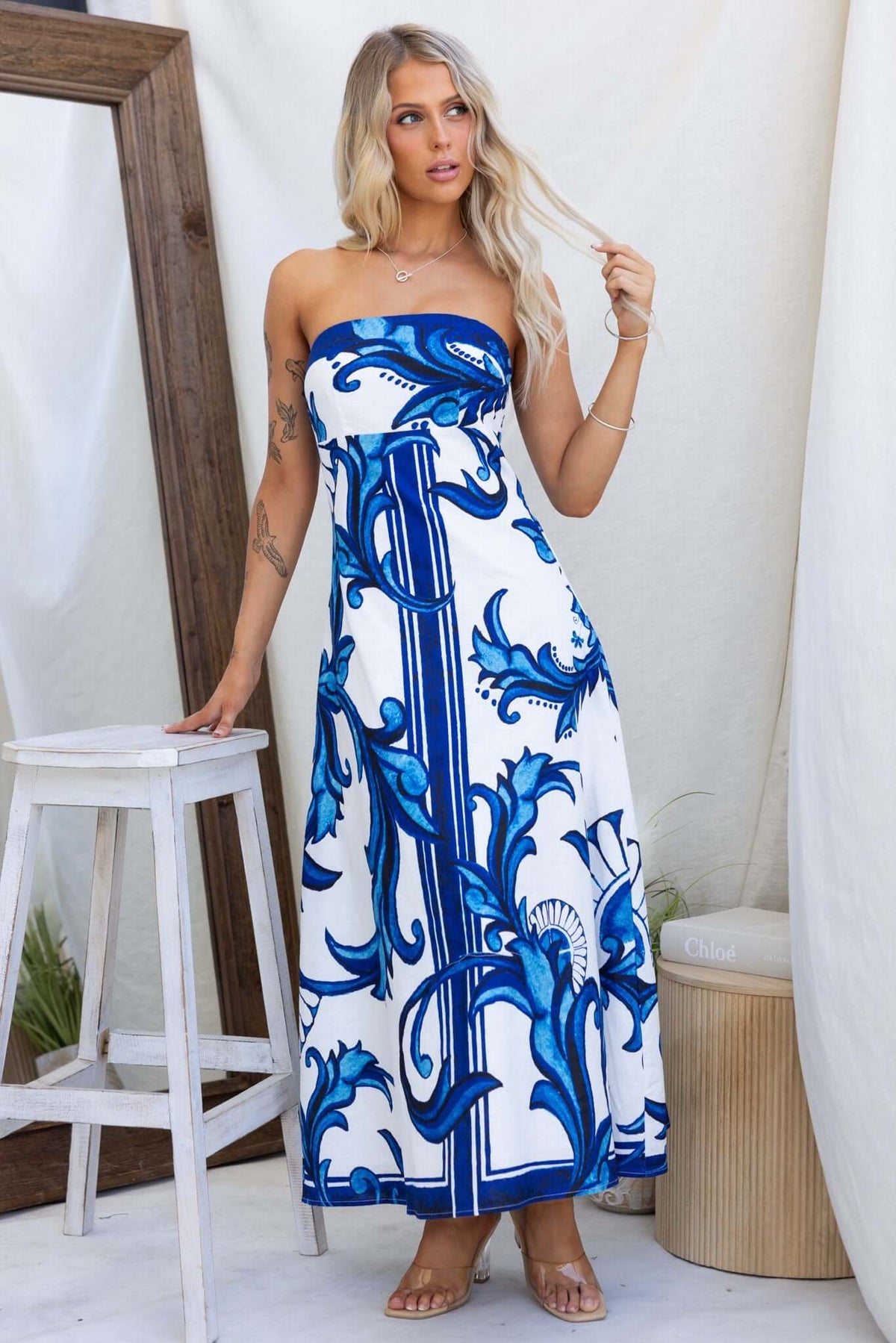 Model wearing a strapless Montclair Maxi Dress in blue and white floral print, featuring a flowing design.