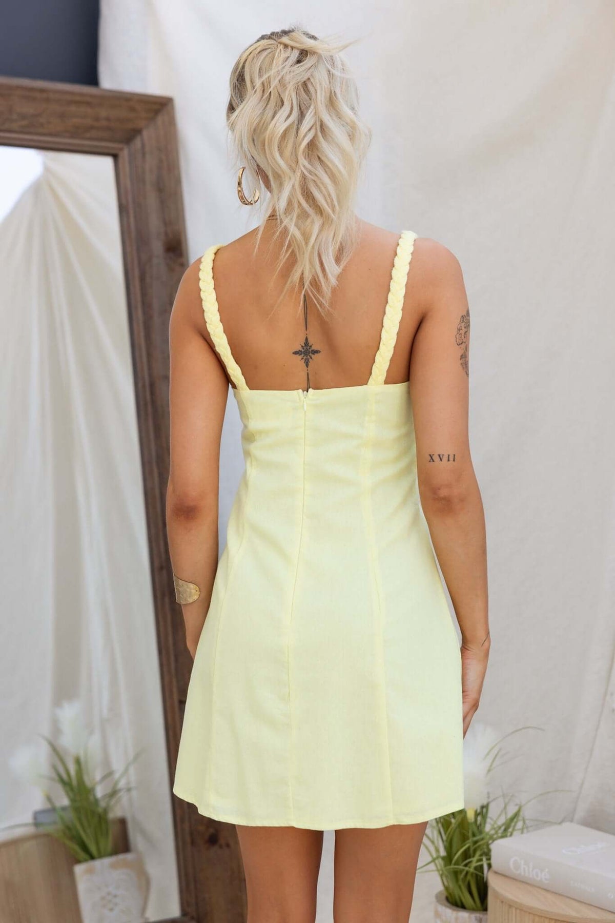 Model wearing the Love Struck Dress in yellow, showcasing the back design and cut-out under bust.
