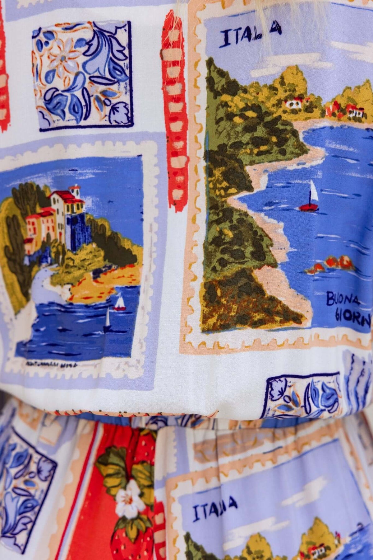 Close-up of colorful Italy-themed print on Fiddler Playsuit featuring scenic landscapes and boats.