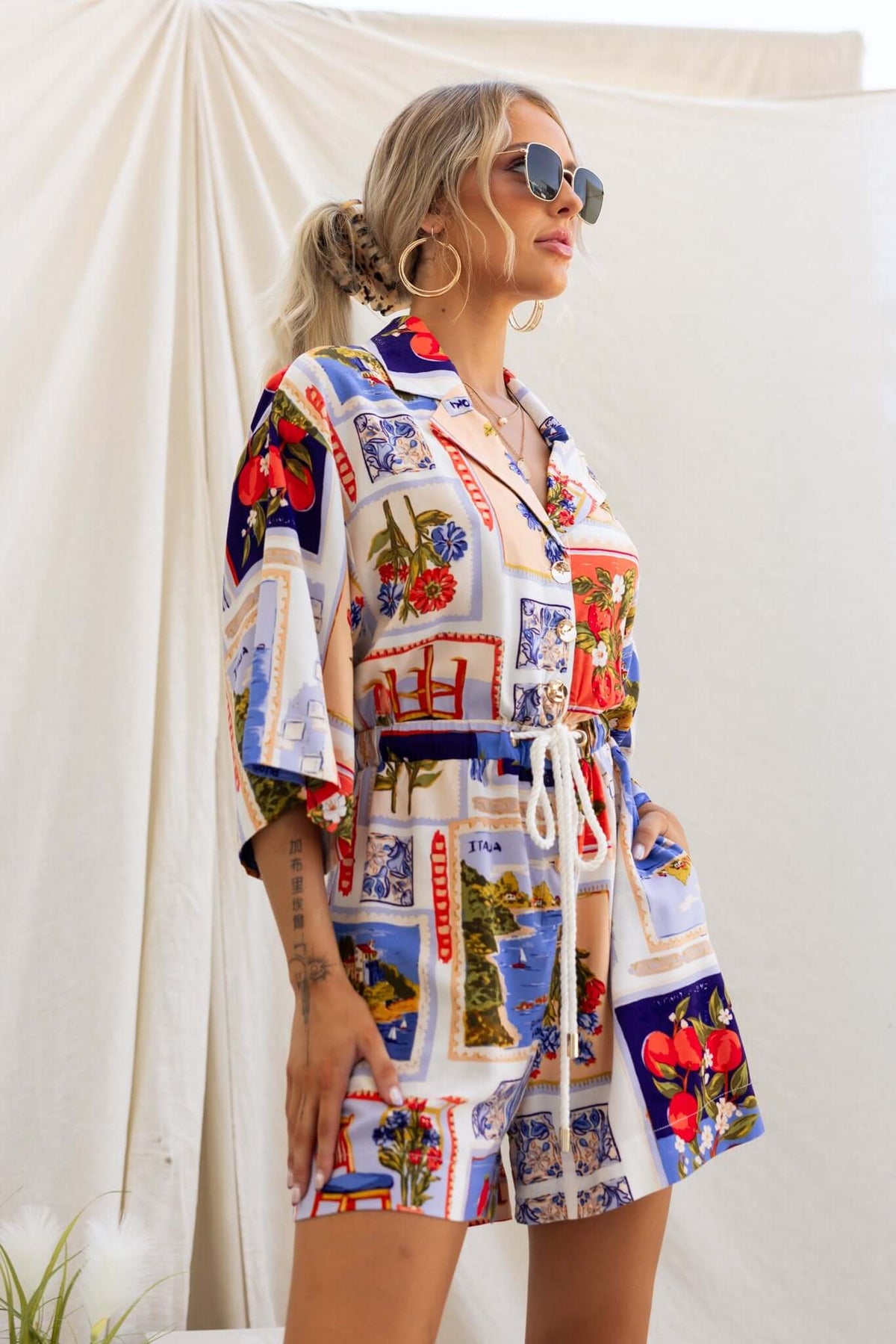 Model wearing a colorful Fiddler Playsuit with a collar, button-up front, and elastic waistband, styled for a relaxed look.