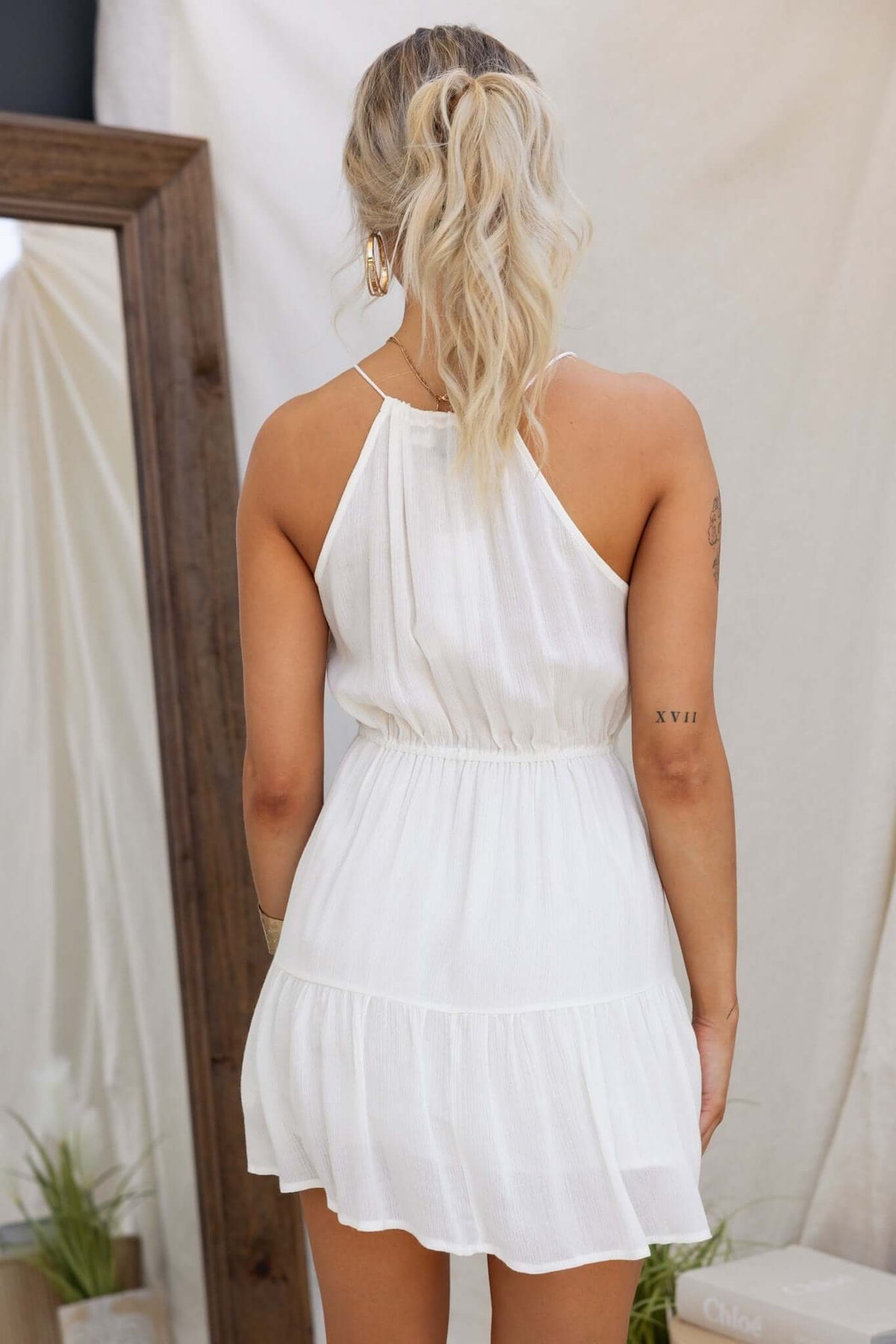 Back view of the Harkin Dress featuring a high tie neckline and elastic waistband, ideal for casual summer wear.