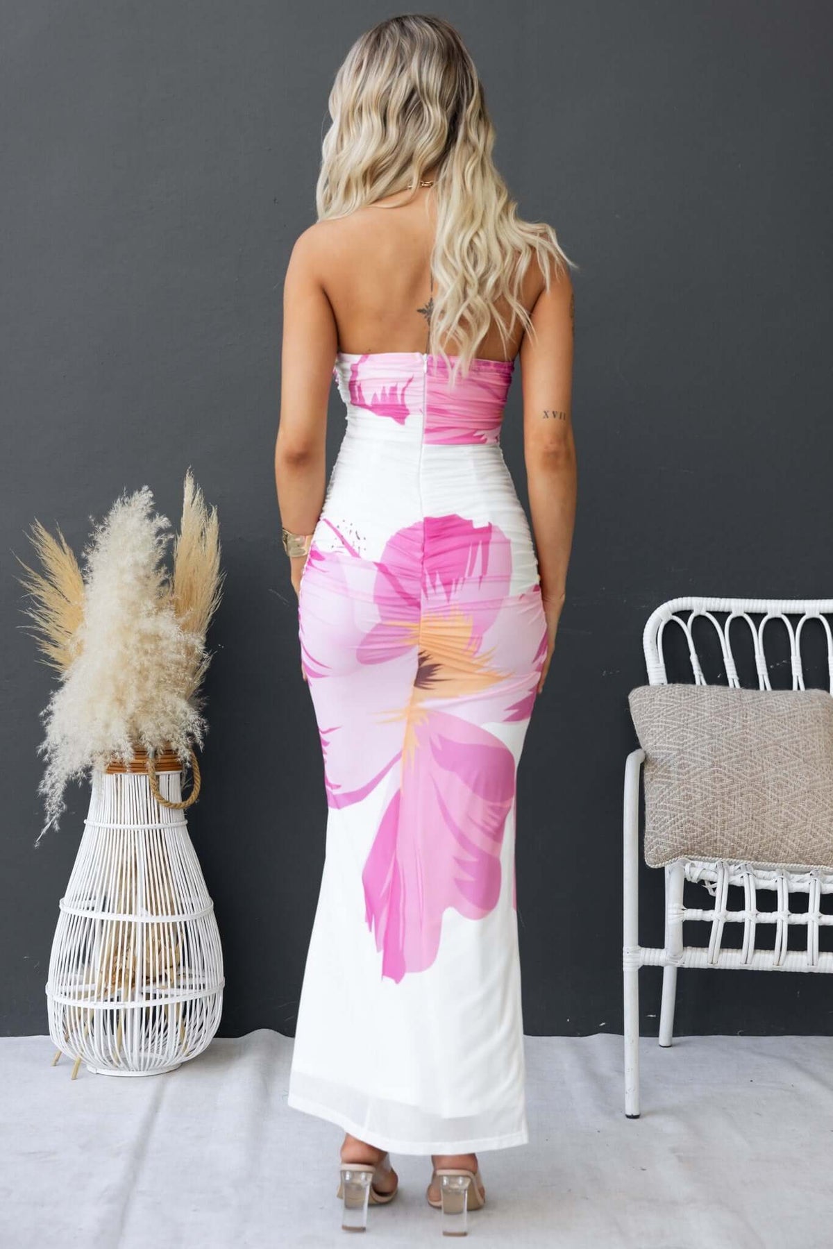 Back view of Taylah in a strapless Pamona Maxi Dress with pink floral print and cut-out detail.