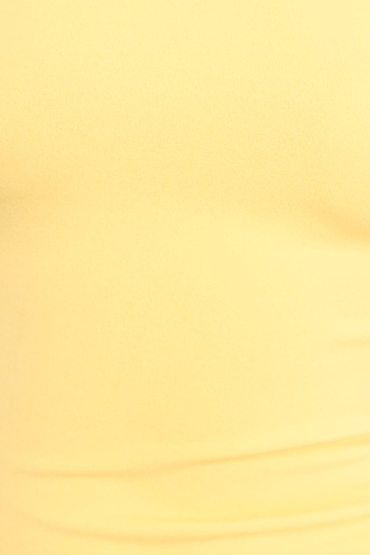 Close-up of soft yellow fabric showcasing the texture of the Kellis Maxi Dress's crepe material.