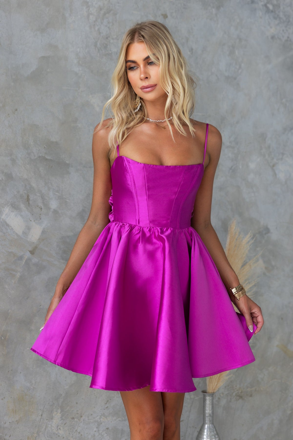 Rosebud Dress in vibrant pink with adjustable straps and a flared skirt, perfect for stylish occasions.