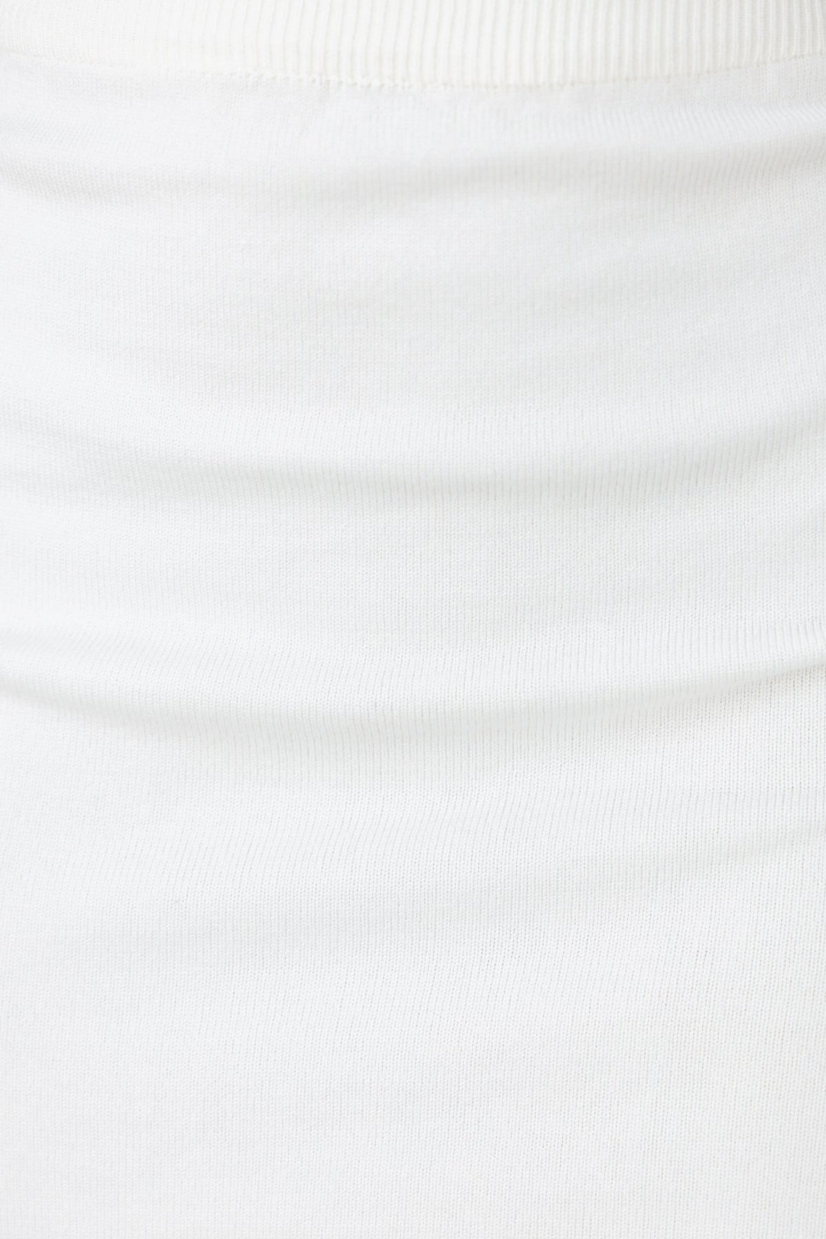 Close-up of Yettie Skirt's white ribbed knit fabric with elastic waistband and mid-high waist fit.