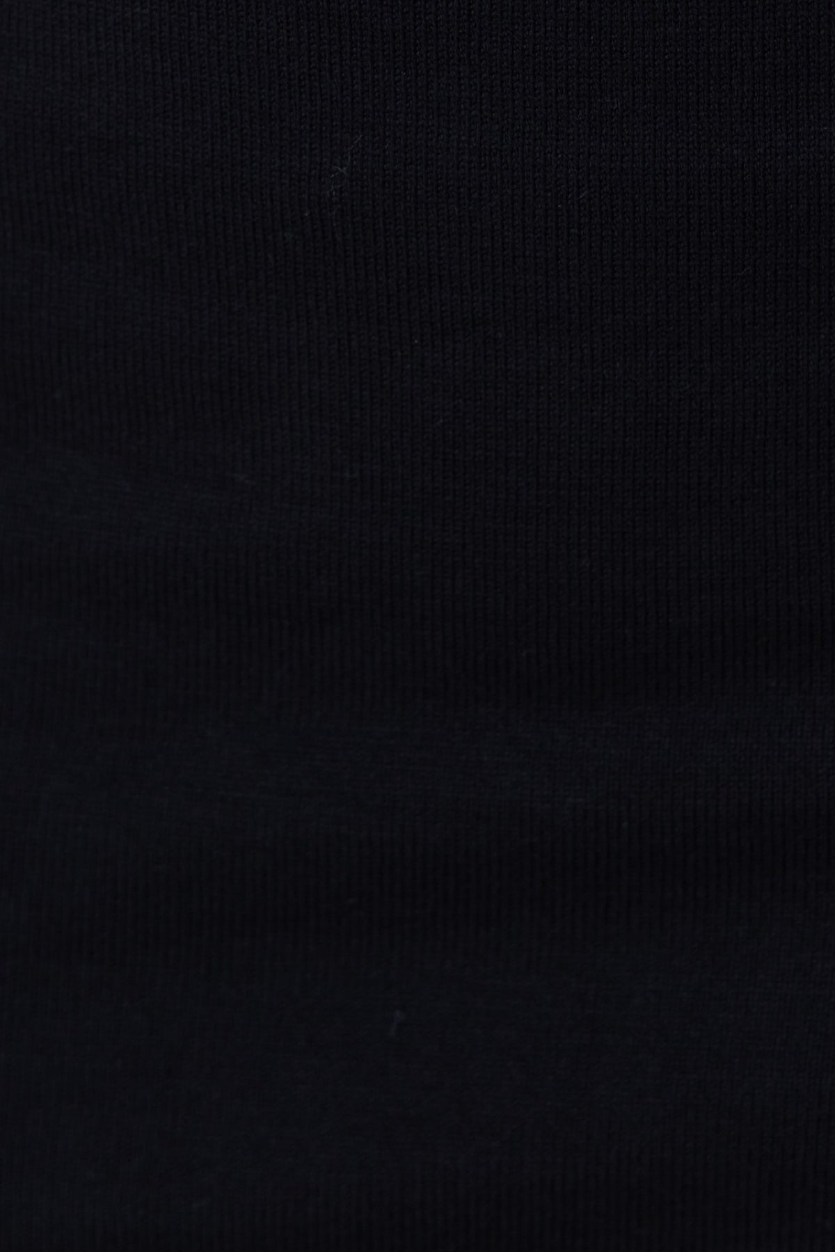 Close-up of ribbed black knit fabric, showcasing adjustable tie neckline and stretchy material for Yettie Top.