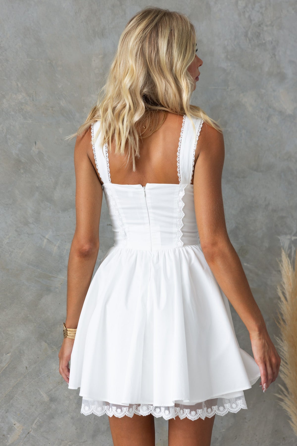 Back view of Cevallo Dress featuring lace detail, white color, and tie detail at bust, perfect for summer occasions.