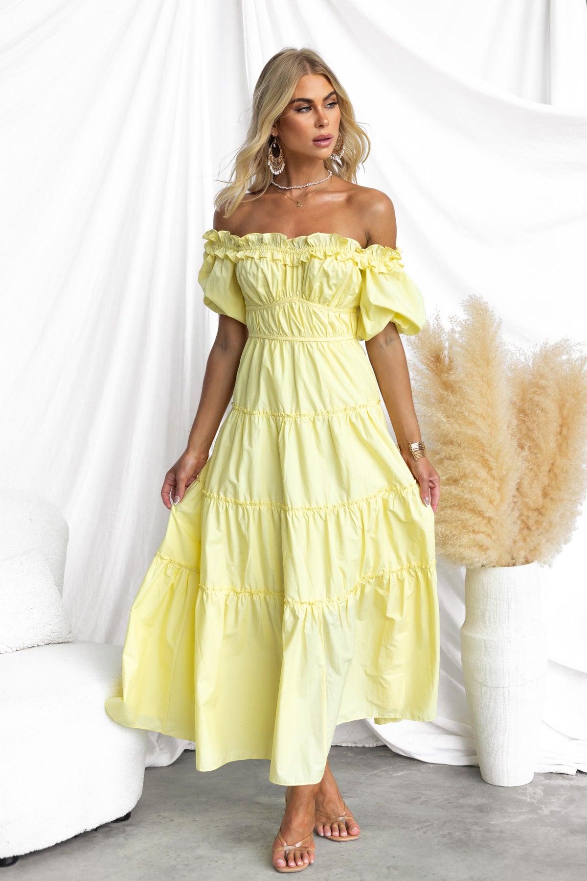 Light yellow off-shoulder maxi dress with ruffles and tiered design, perfect for summer occasions.