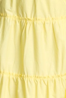 Close-up of the yellow cotton fabric with gathered tiers, showcasing the texture of the Archer Maxi Dress.