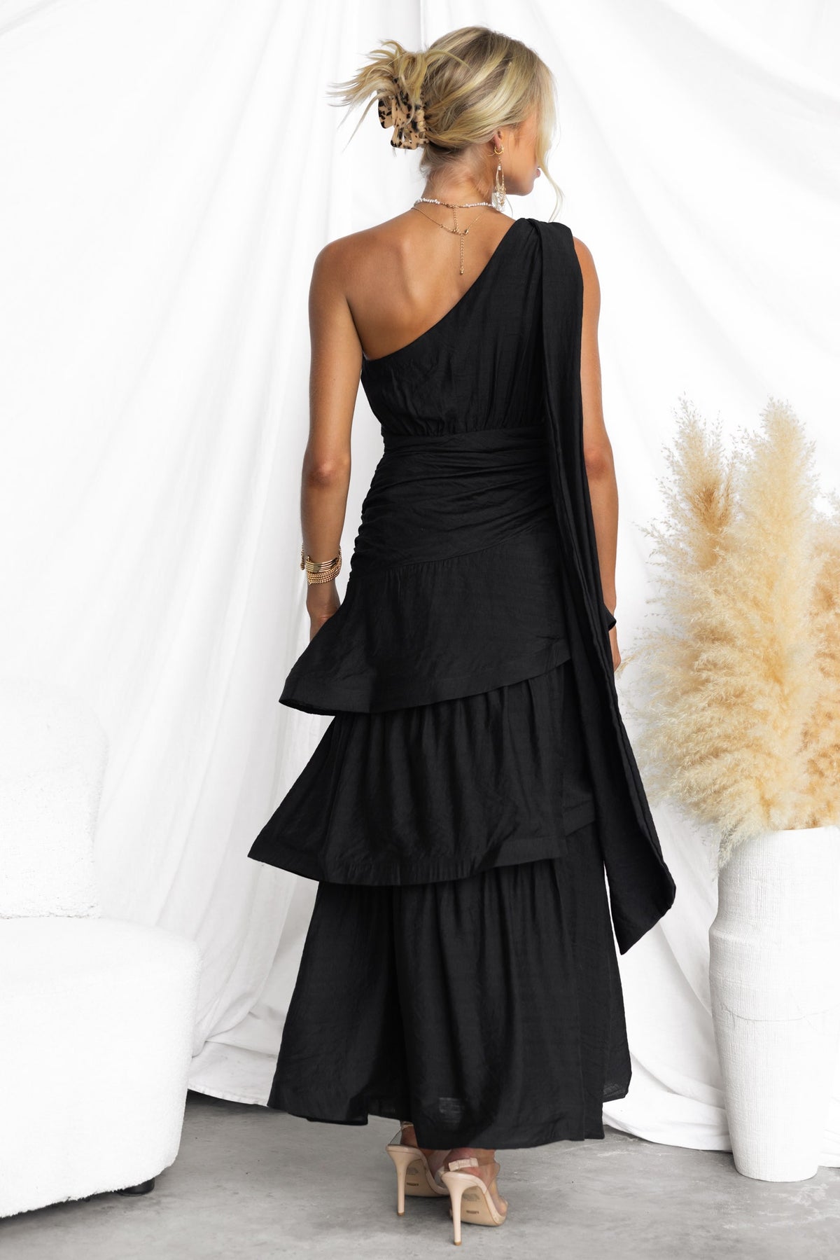 Back view of the elegant black Bentley Maxi Dress featuring a one-shoulder design and ruffled hem.