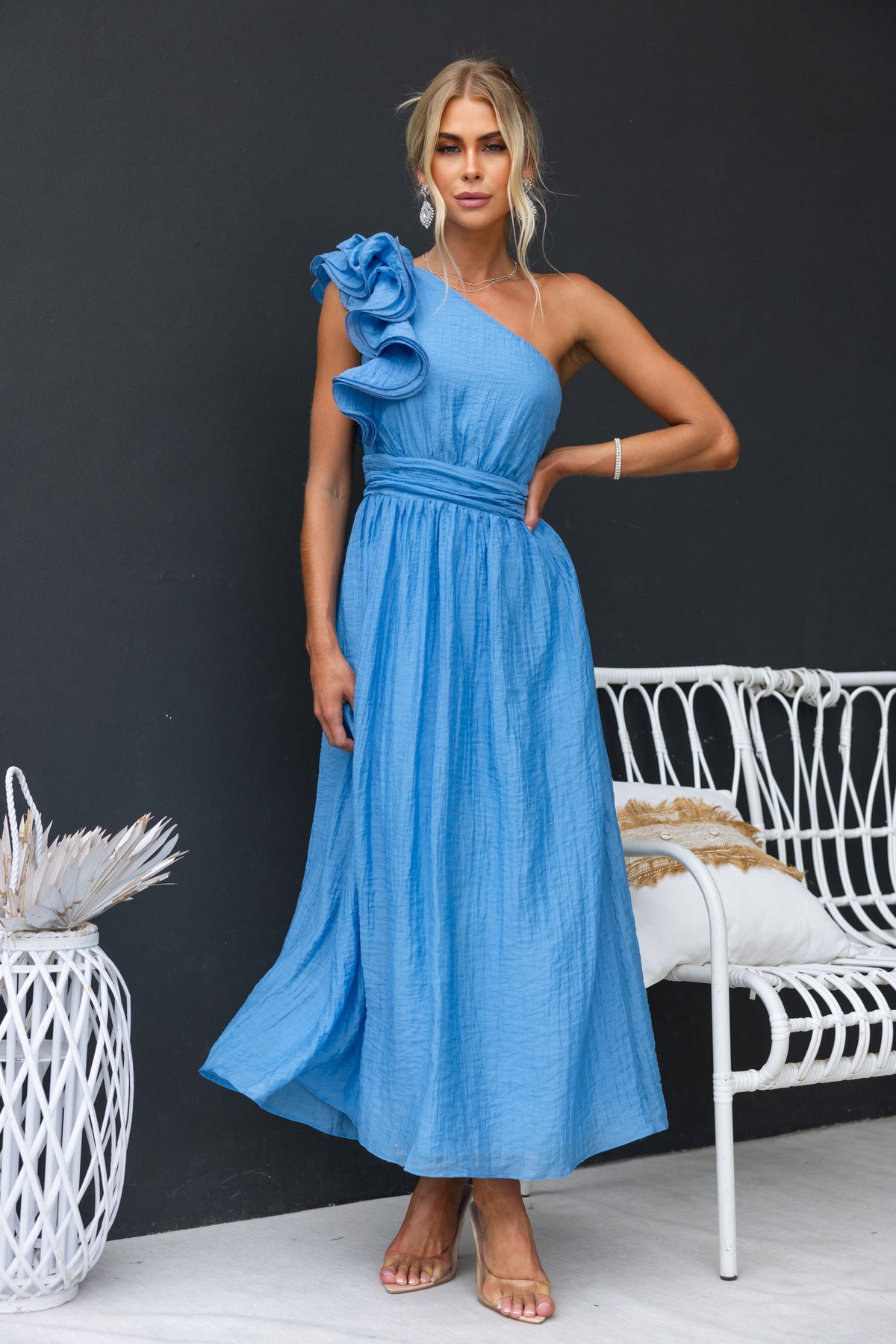Model wearing the Etsa Maxi Dress, a blue one-shoulder dress with ruffle detail and chiffon fabric, perfect for special occasions.