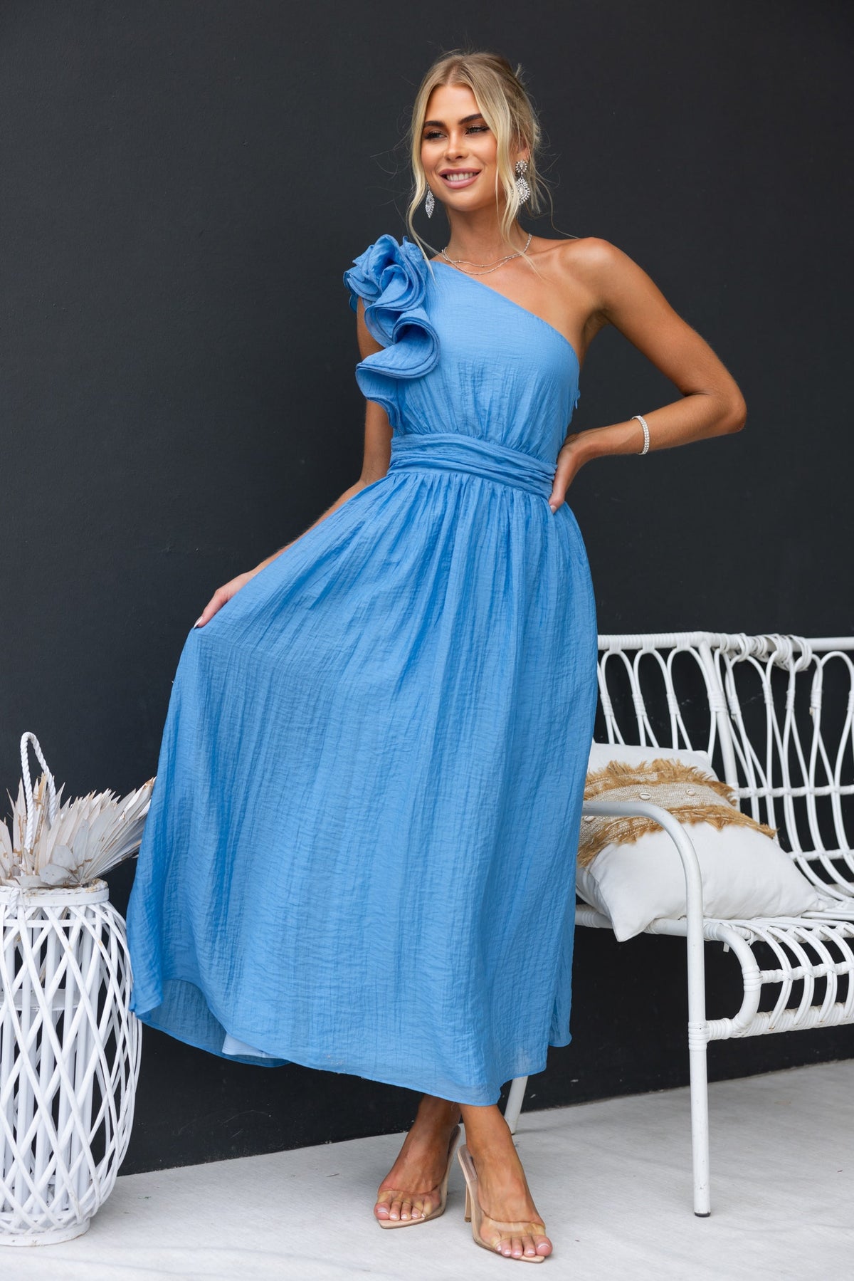 Model wearing a blue Etsa maxi dress with ruffle detail and one-shoulder neckline, perfect for summer occasions.