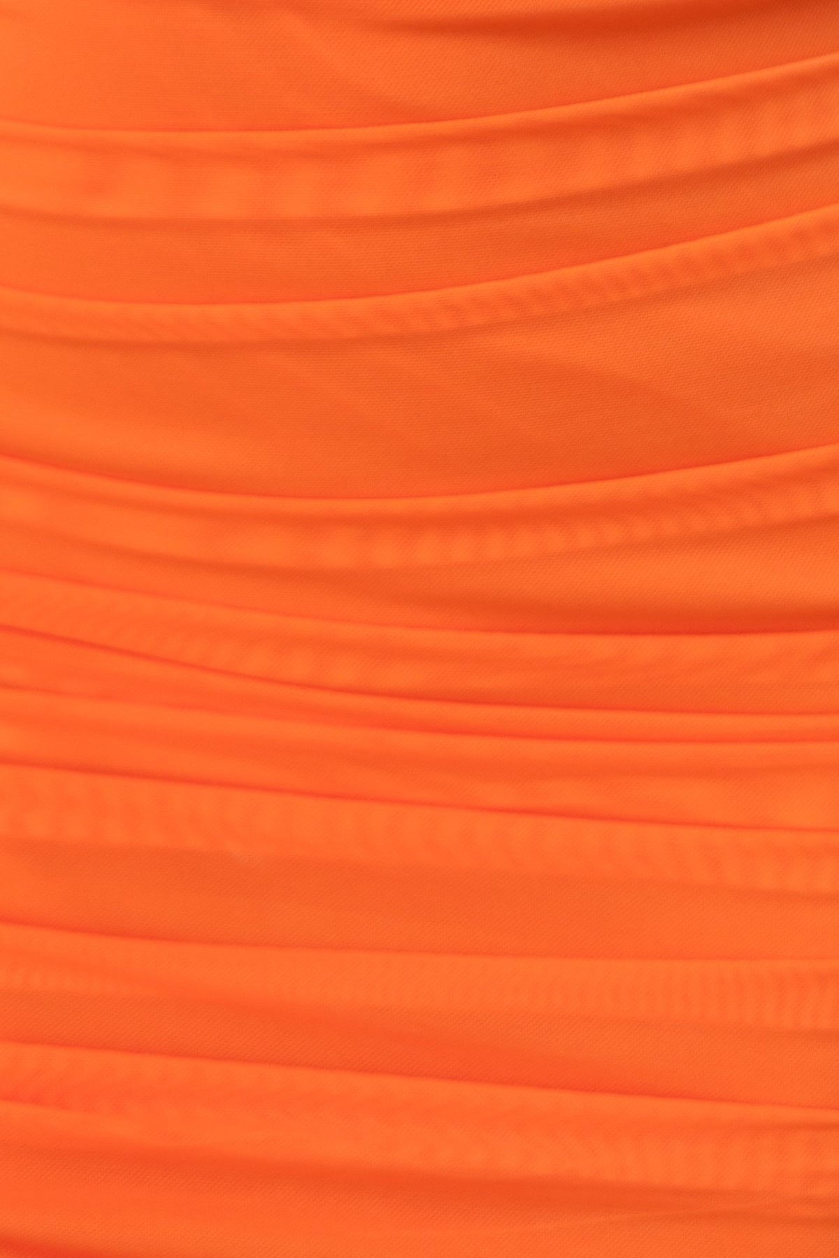 Close-up of orange draped fabric, showcasing the ruching details of the Big Dreams Dress.
