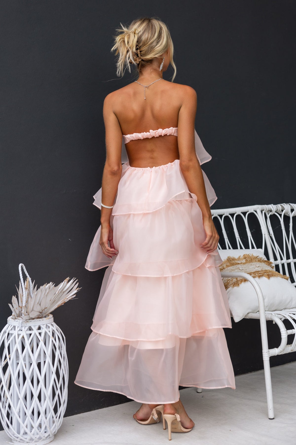 Back view of Lilianna Maxi Dress in soft pink chiffon, showcasing strapless design and layered ruffles.