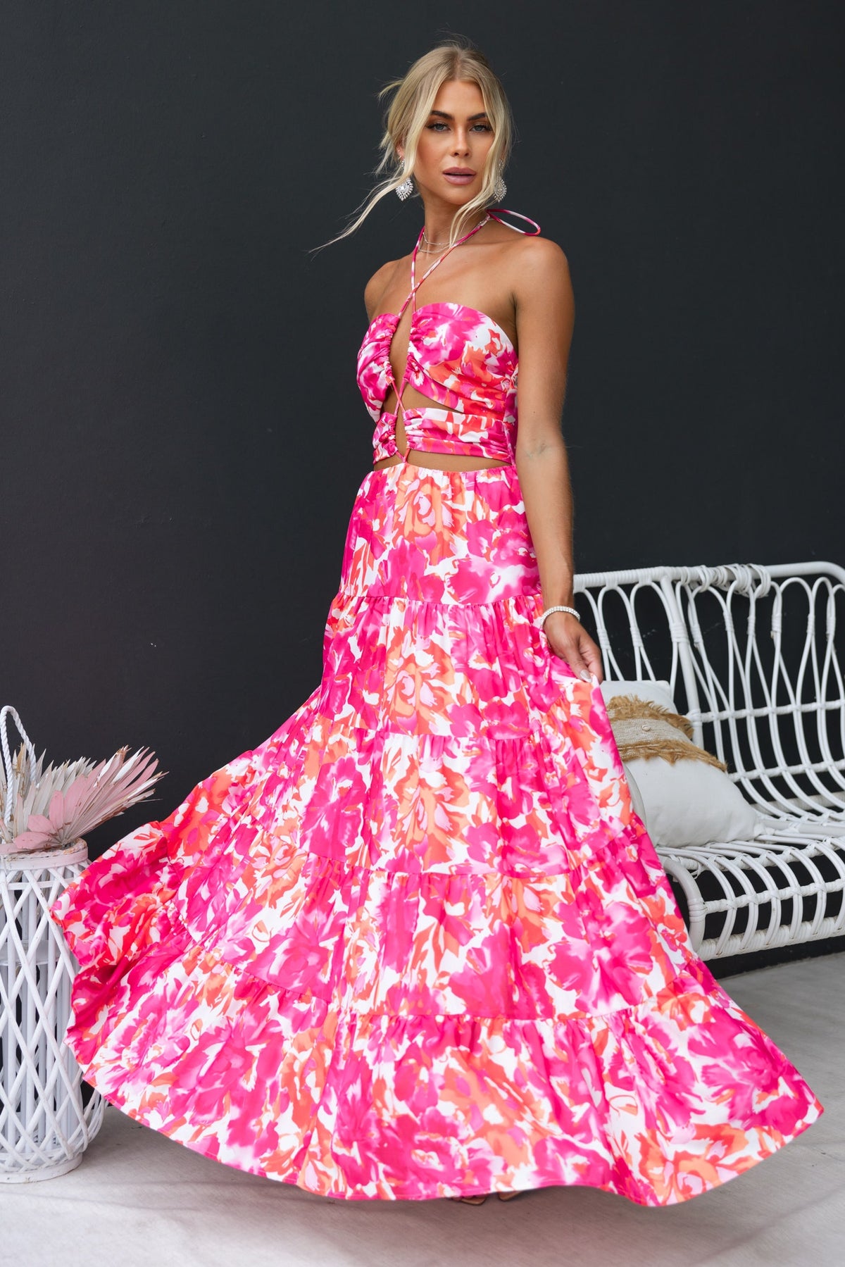 Lauri Maxi Dress in floral print, featuring a tie halter neck and cut-outs, worn by a model against a black background.