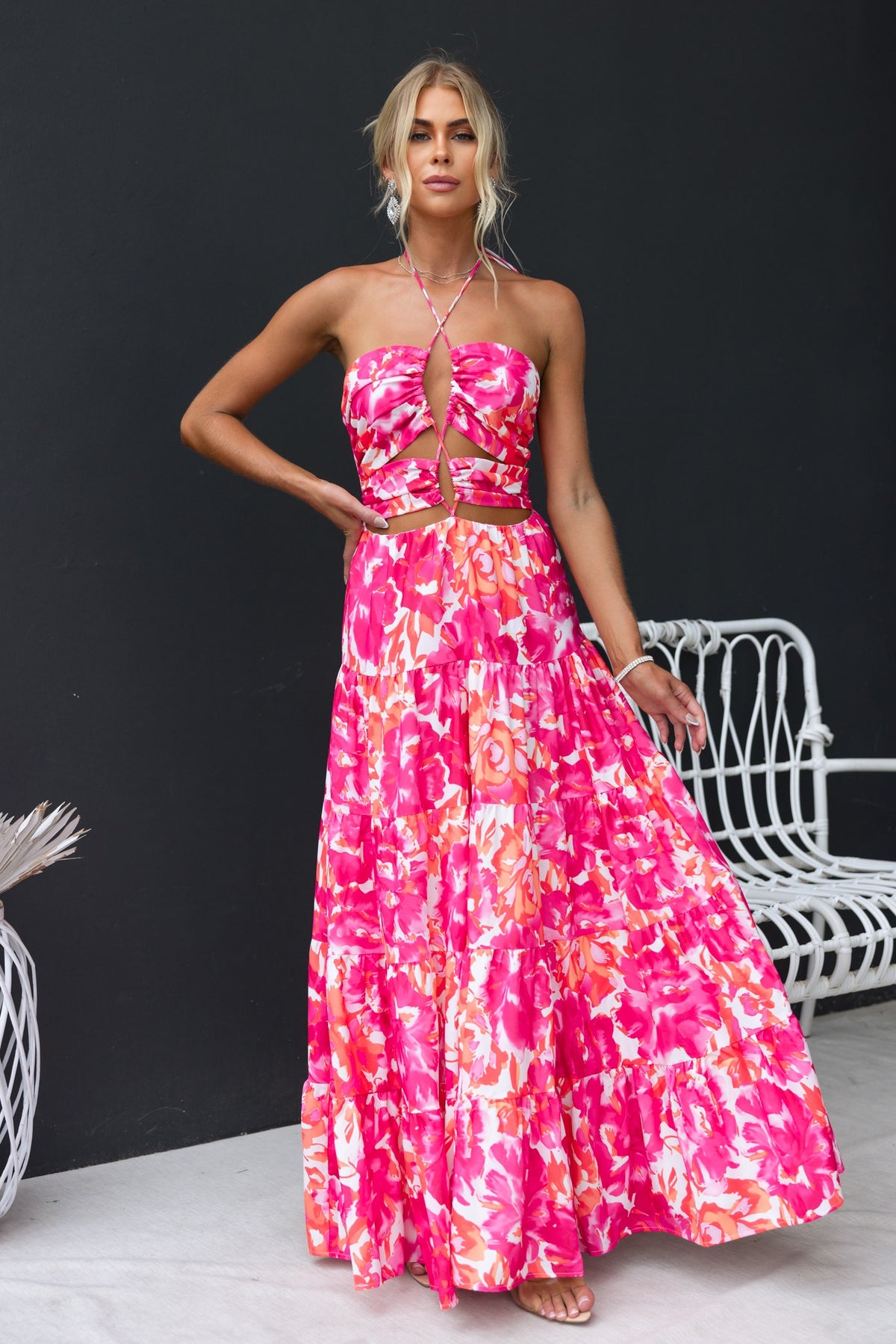 Model wearing Lauri Maxi Dress, a floral maxi dress with halter neckline and cut-outs, perfect for summer occasions.