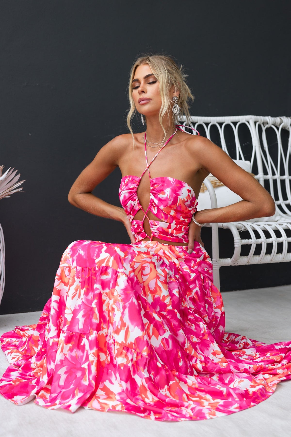 Lauri Maxi Dress with floral print, adjustable halter neckline, and cut-outs worn by model in a stylish setting.