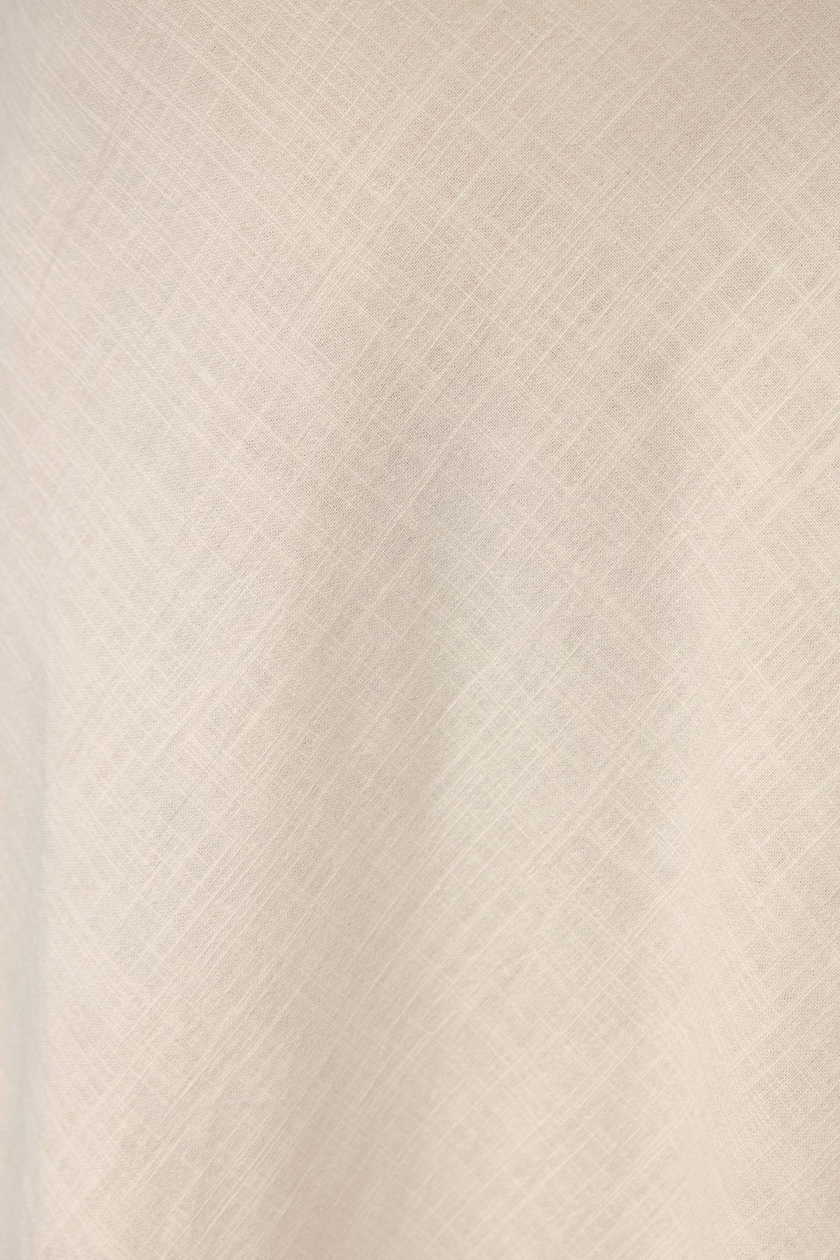 Close-up of textured fabric in a soft cream color, showcasing the cotton-like feel for the Shana Maxi Skirt.