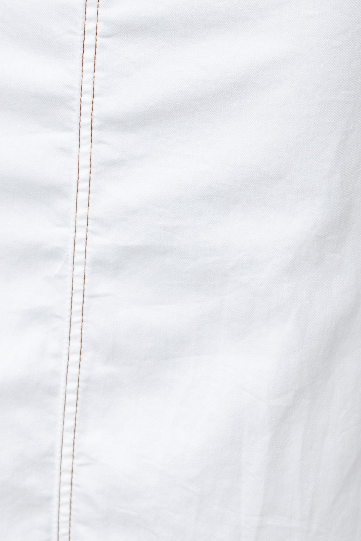 Close-up of white fabric with visible stitching, showcasing texture and quality for apparel design.