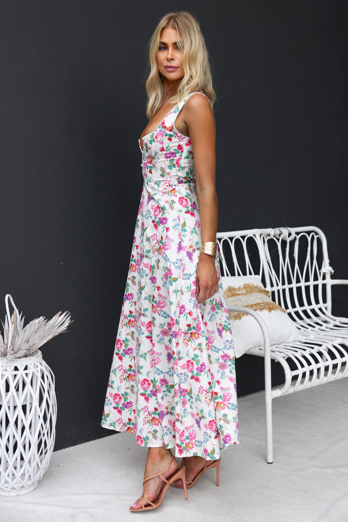 Keely Midi Dress featuring floral print, adjustable straps, and a flowing silhouette, styled with strappy heels.