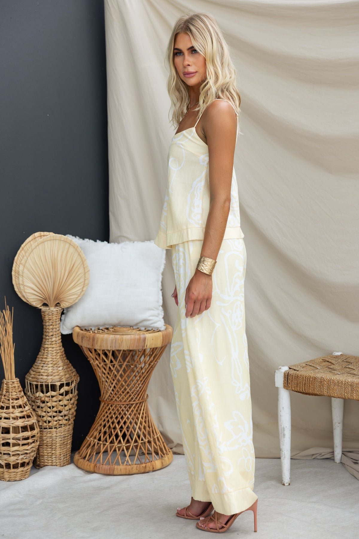 Model wearing Izobelle Set, featuring a yellow linen look top and matching pants with elegant patterns.