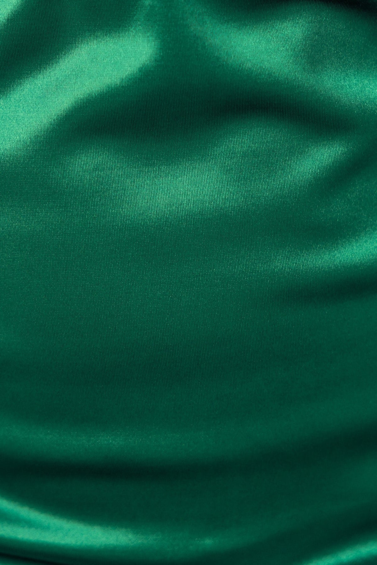 Close-up of the shiny green fabric of the Nakina Dress, showcasing its smooth texture and sheen.