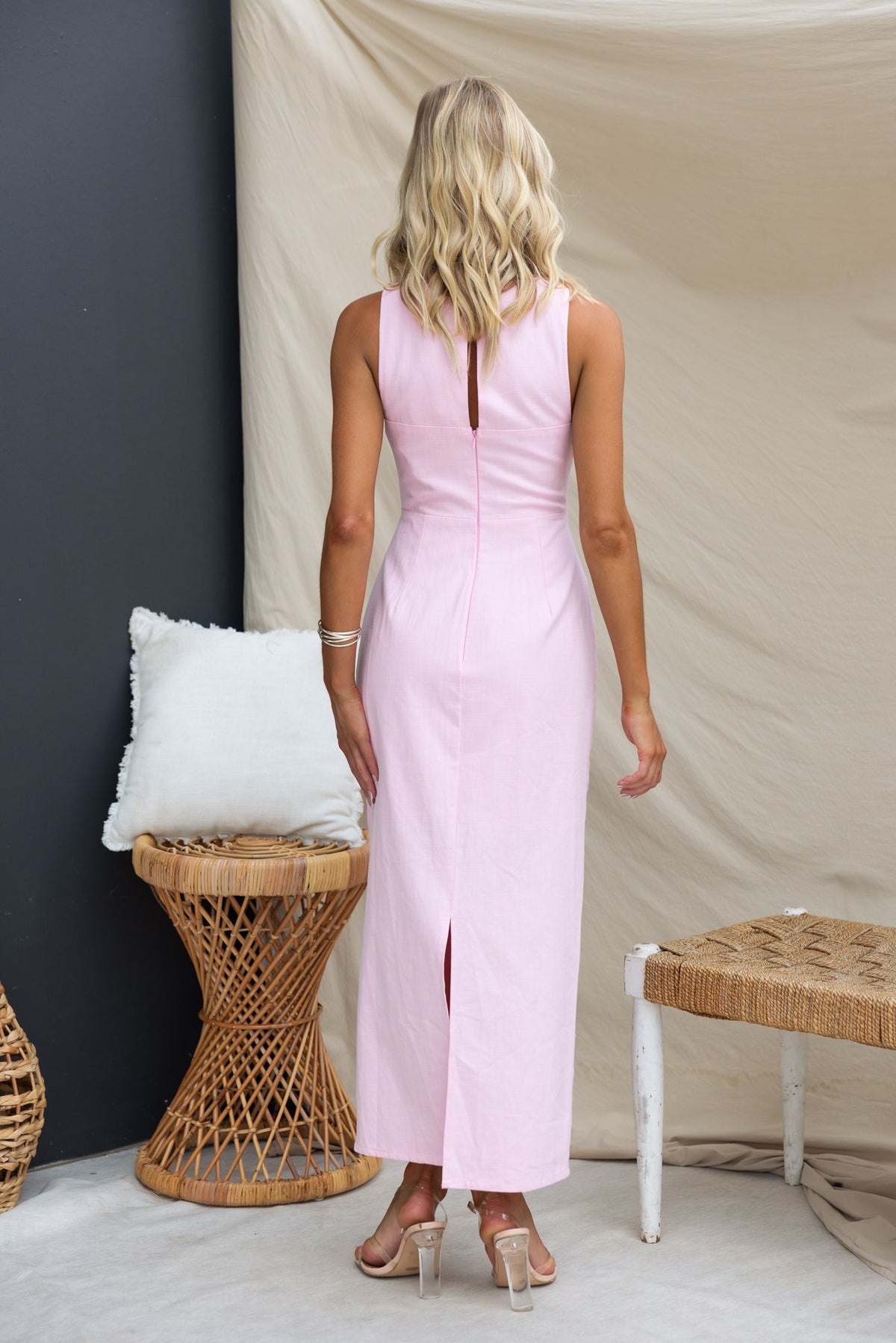 Model wearing a pink Mirai maxi dress with a back split and keyhole detail, styled against neutral backgrounds.
