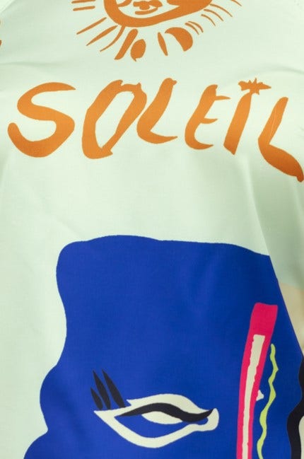 Close-up of colorful fabric featuring 'Soleil' text and abstract designs in blue and orange.