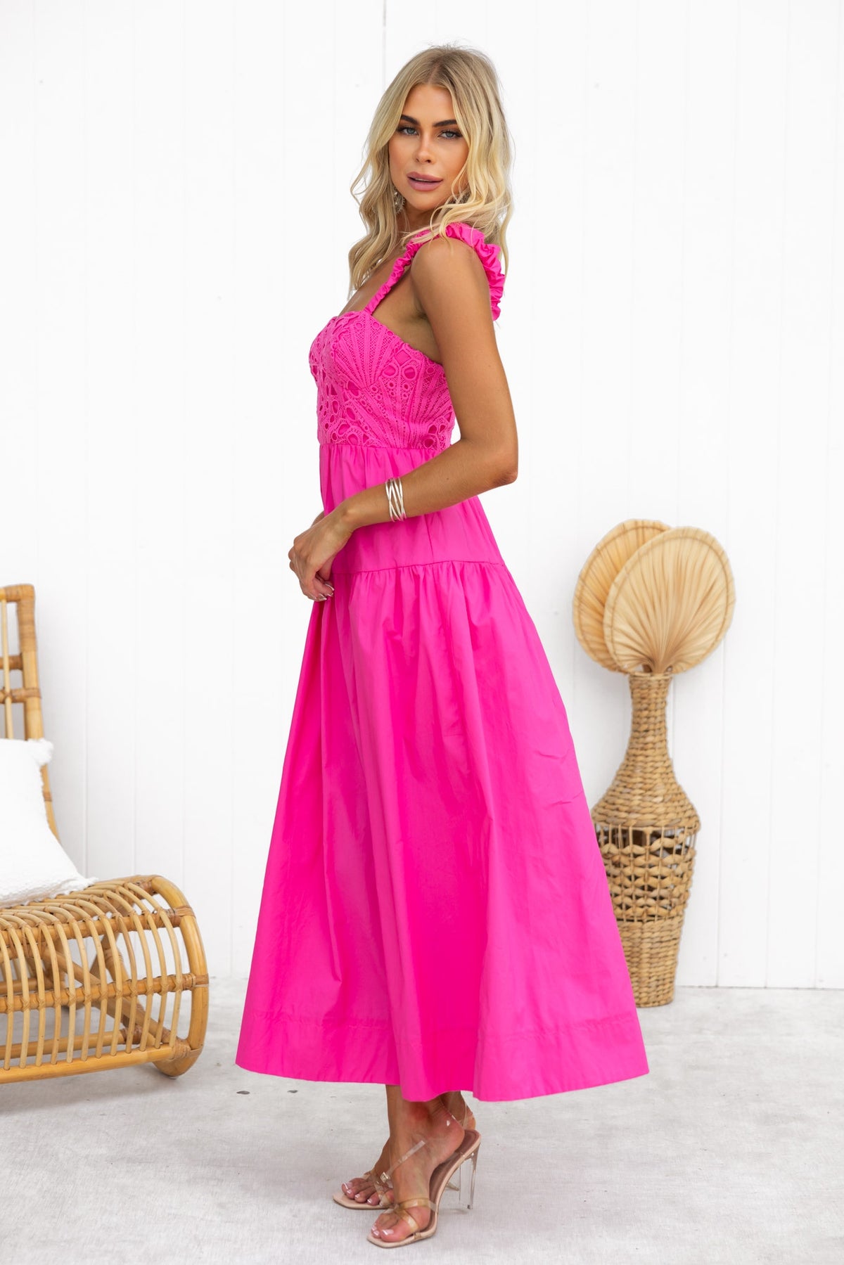 Model wearing Neisha Maxi Dress in bright pink with lace detailing and elastic straps against a minimalist background.