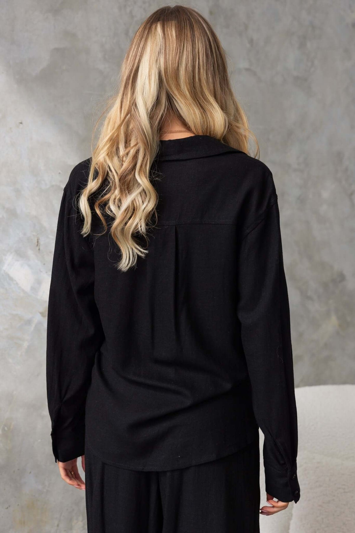 Back view of a black Umali shirt with a relaxed fit, designed for summer wear in soft linen texture.