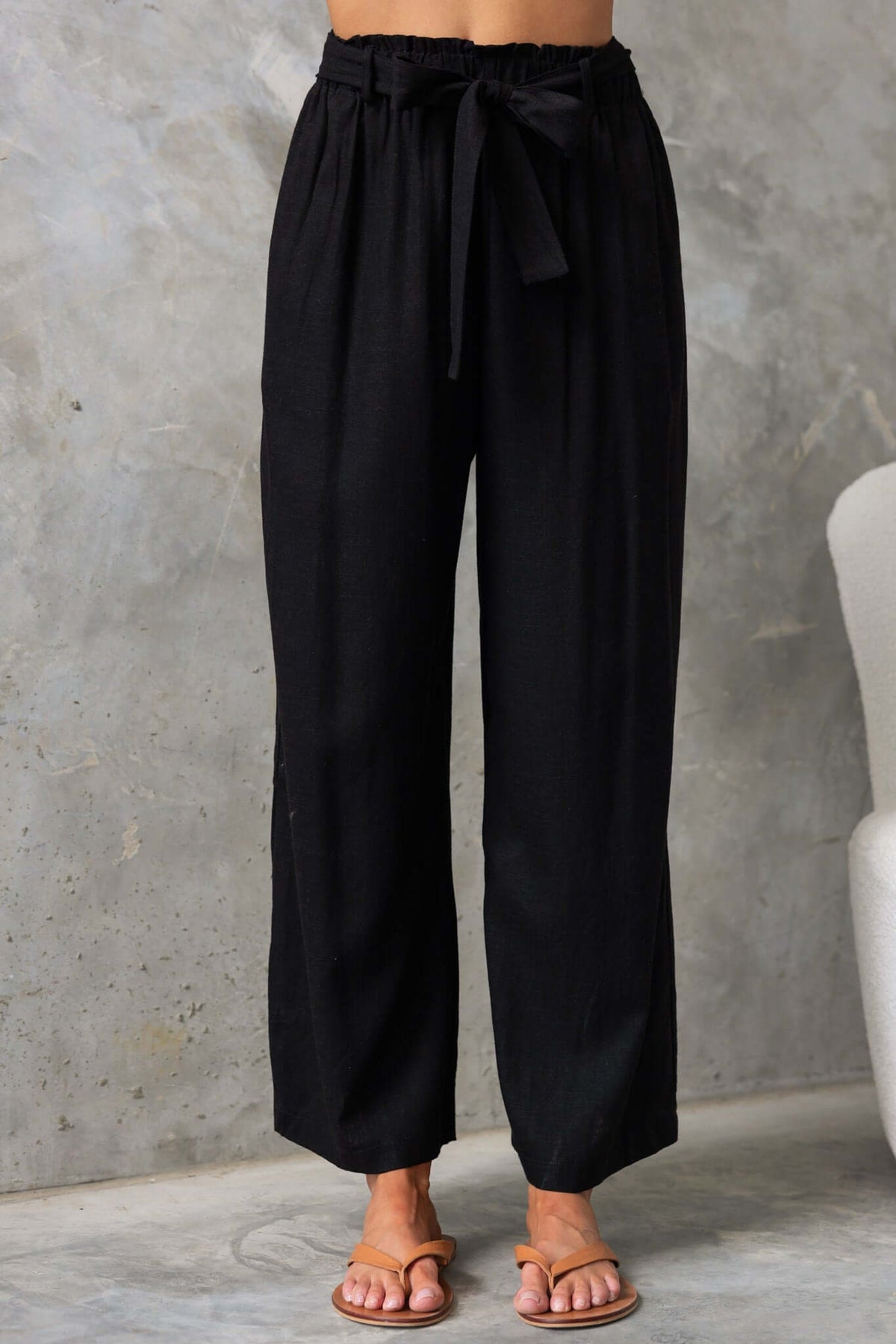 Umali Pants: Black mid-high waist linen look pants with elastic waistband and removable tie, perfect for summer wear.
