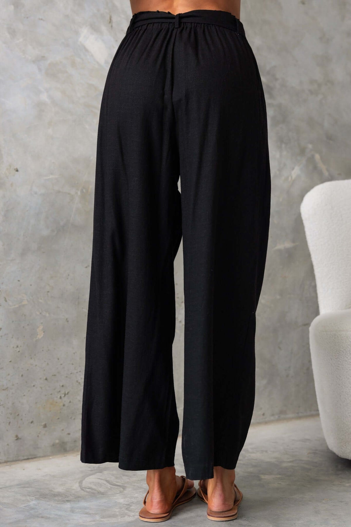 Back view of Umali Pants showcasing mid-high waist fit, elastic waistband, and wide-leg design in black.