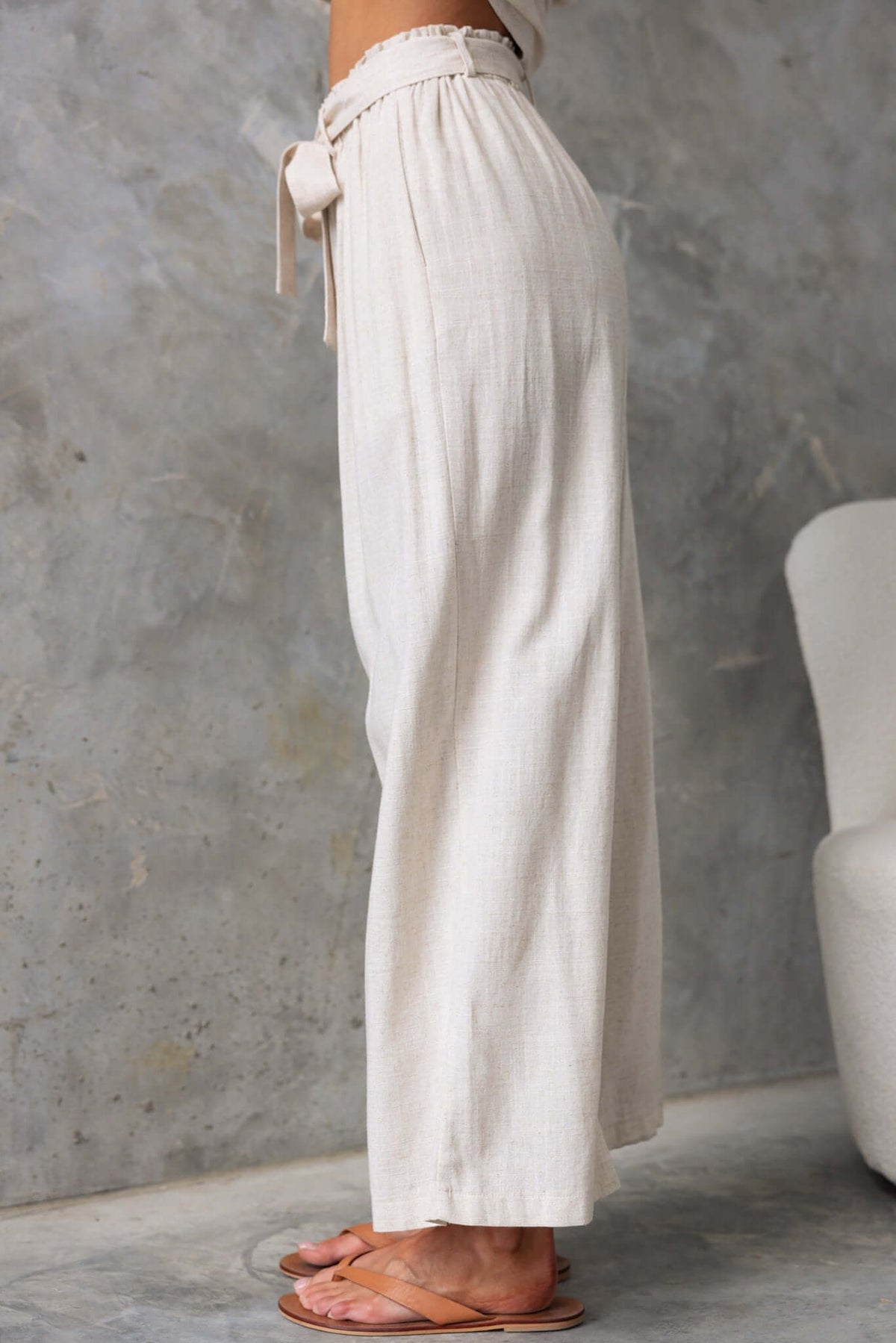 Umali Pants in a light linen fabric, featuring a mid-high waist, elastic waistband, and removable tie.