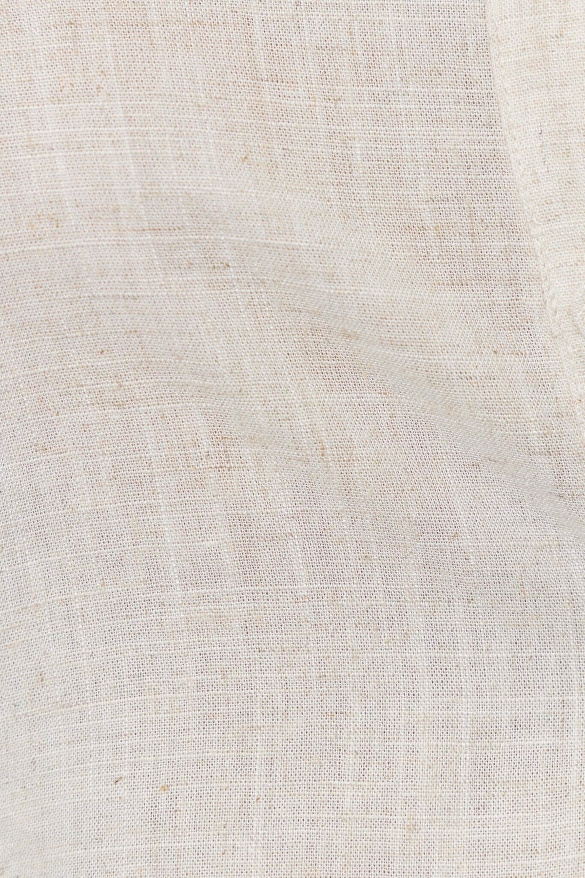 Close-up of lightweight linen fabric in a soft off-white color, showcasing its smooth texture and natural weave.