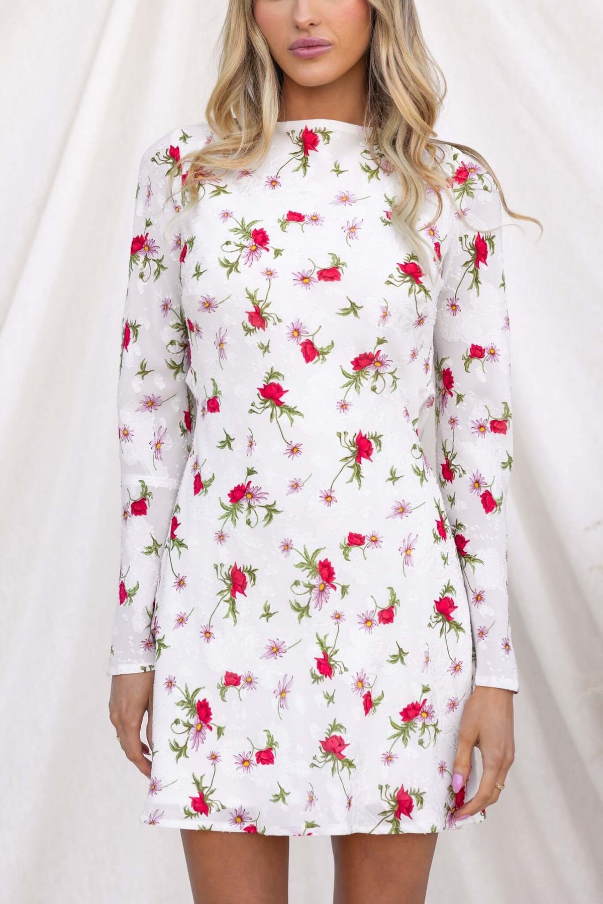 Alluring white dress with red floral print, featuring a boat neckline and long sleeves, perfect for summer occasions.