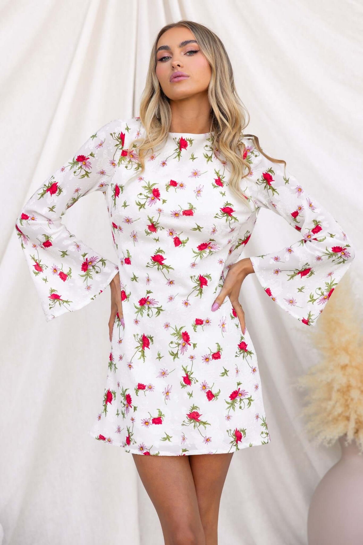 Alluring white floral dress with bell sleeves, perfect for summer wear and featuring a stylish boat neckline.