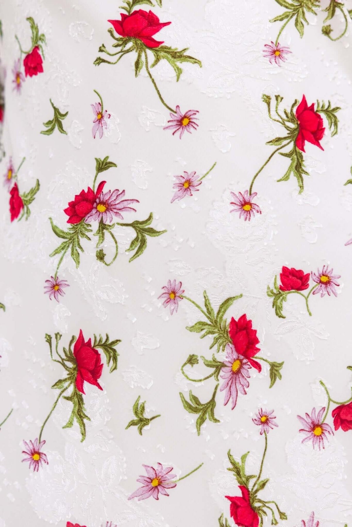 Floral patterned fabric featuring red roses and pink daisies on a white textured background.