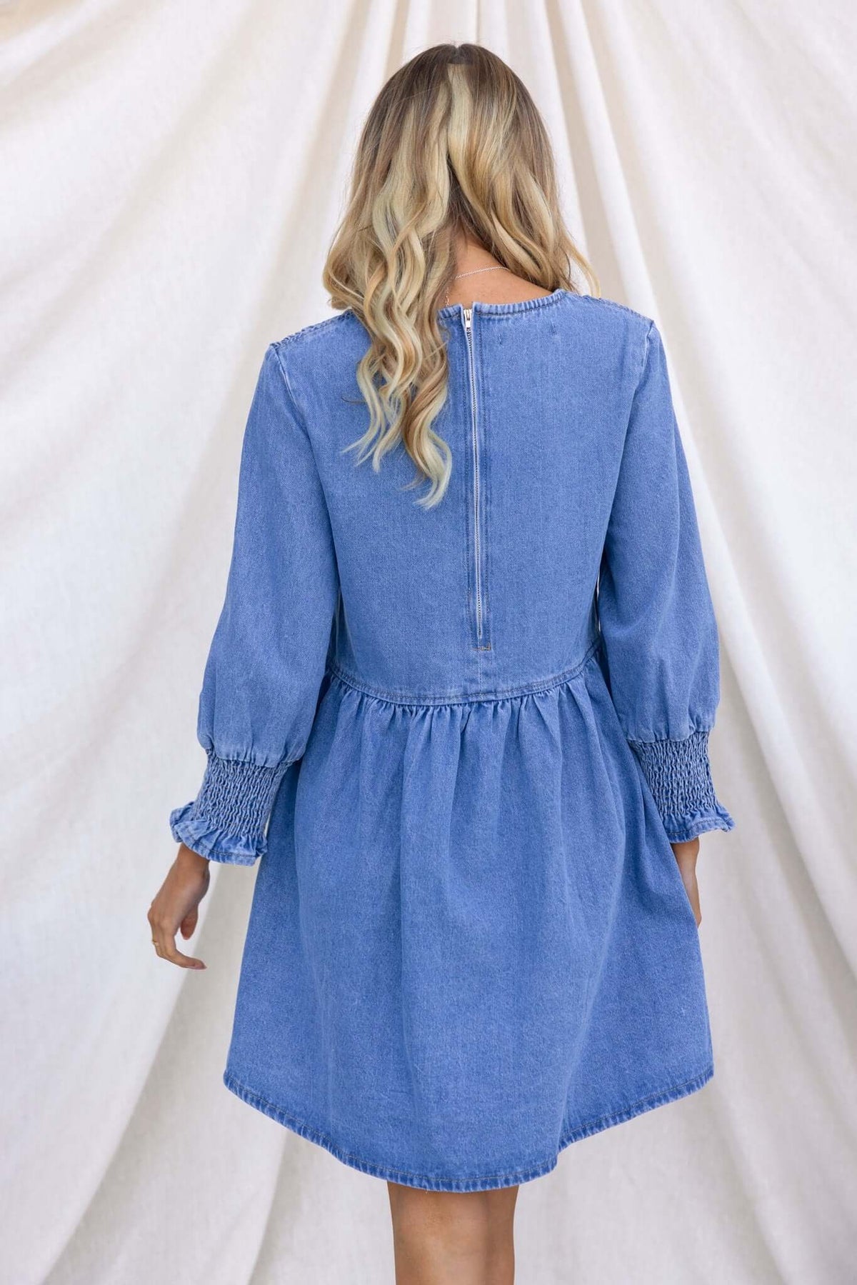 Back view of the Tulsa Denim Dress showcasing elastic sleeves and back zipper.