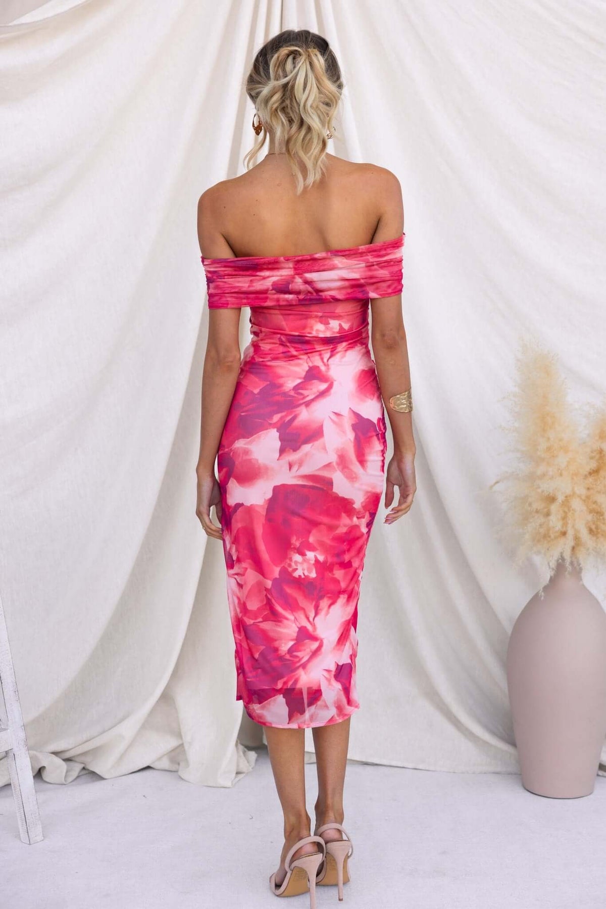 Back view of Talinga Midi Dress with floral print, off-shoulder design, asymmetric hem, perfect for summer occasions.
