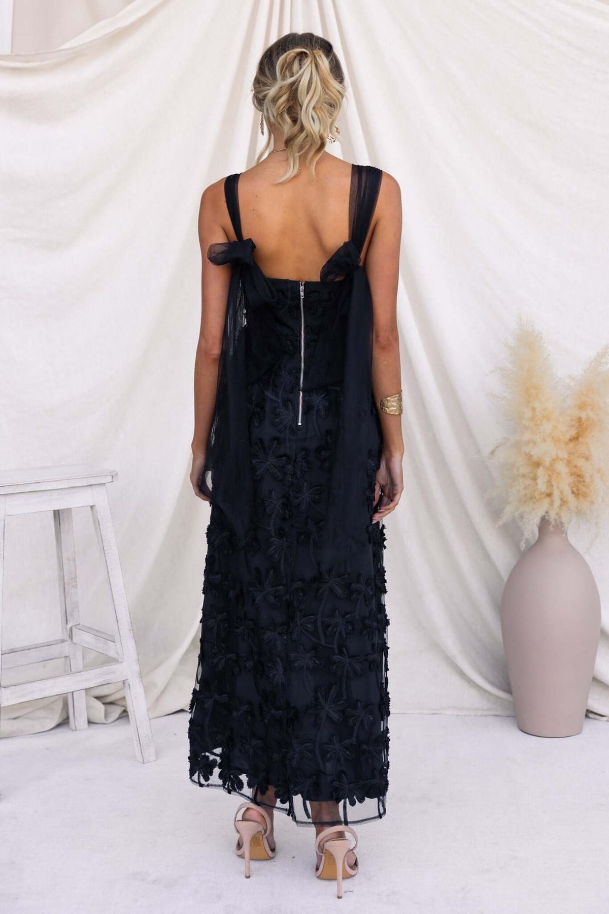 Back view of the Xaria Maxi Dress featuring tie straps, tulle embroidered material, and a zip closure.