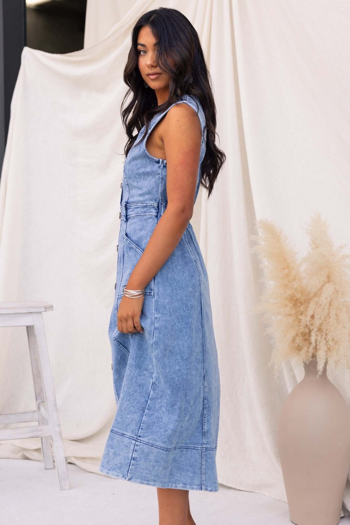 Kerrie Denim Midi Dress featuring V-neckline, pockets, and side zip, styled with relaxed hair in a light backdrop.